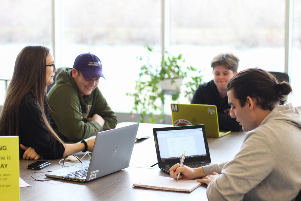 Several people working on laptops around a table