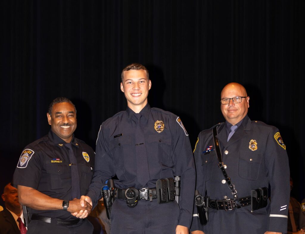 Three policemen smiling at the camera.