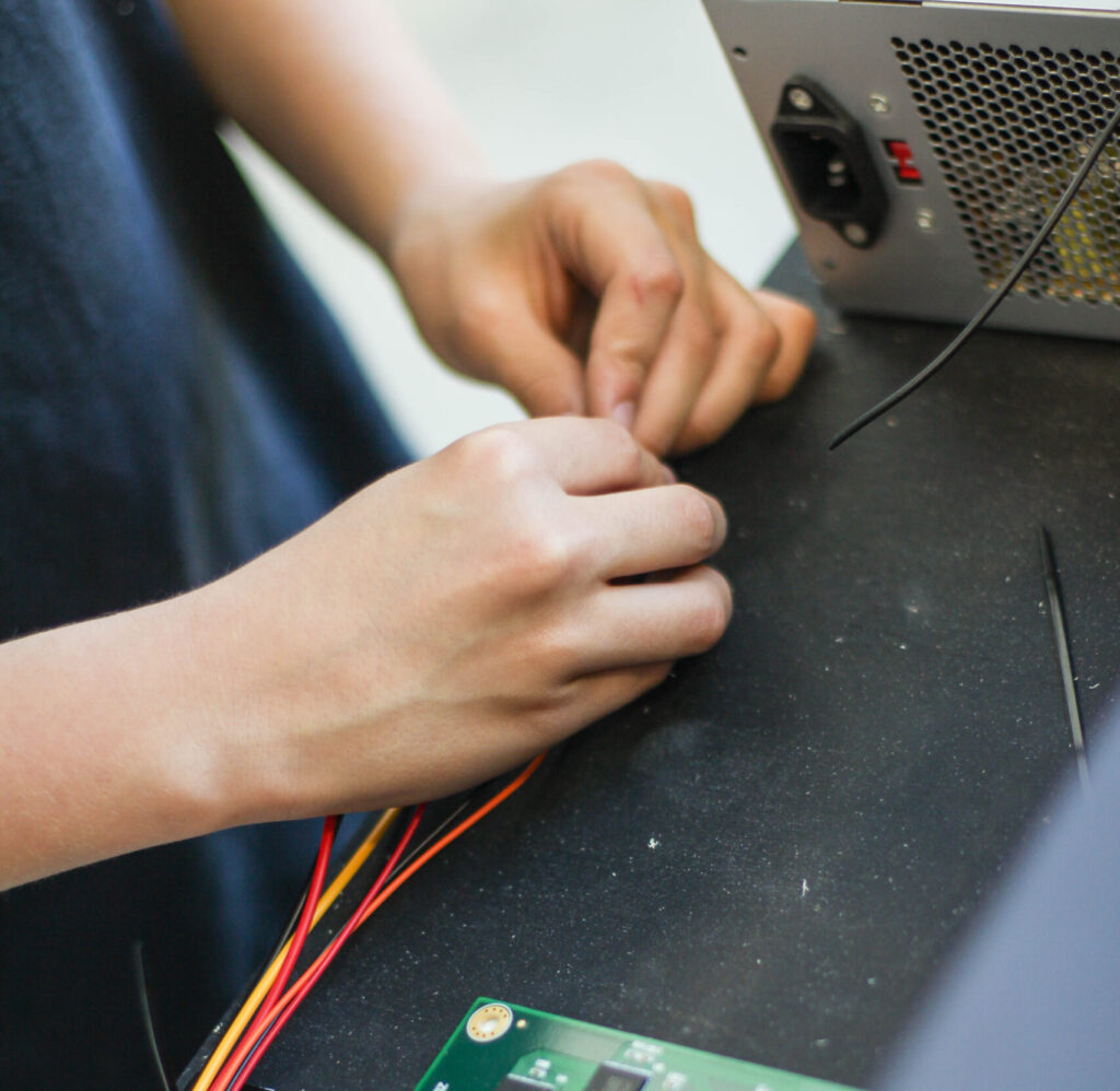 A person twisting wires together.
