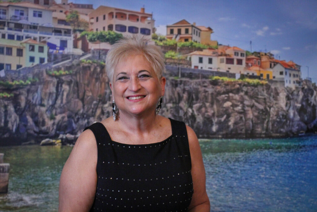 Woman standing in front of European backdrop and smiling at the camera.