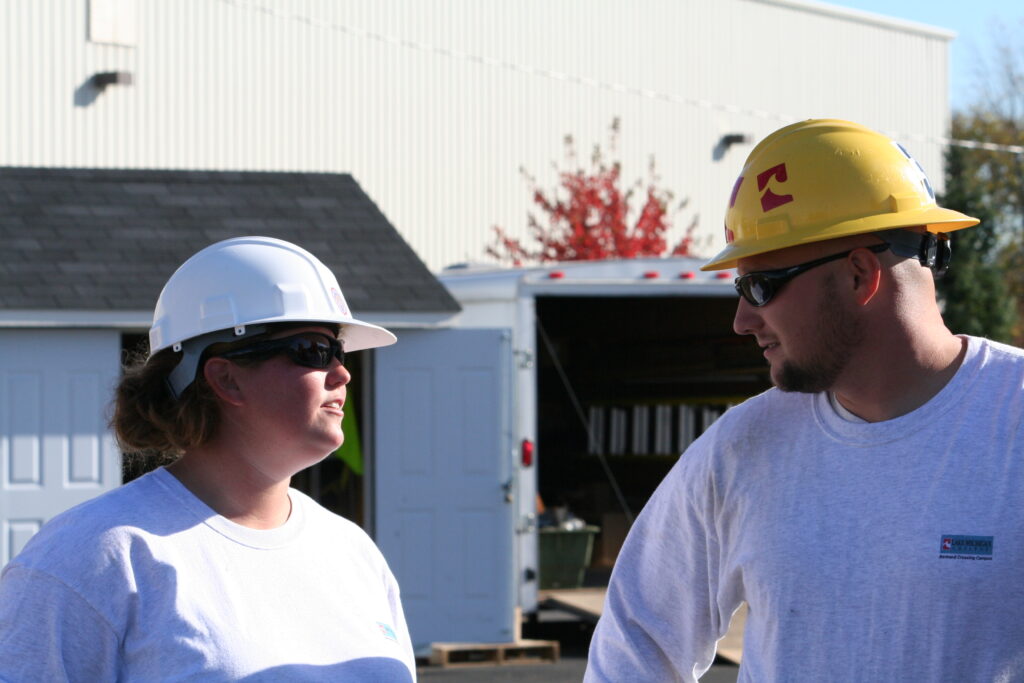 Two people wearing helmets talking to each other.