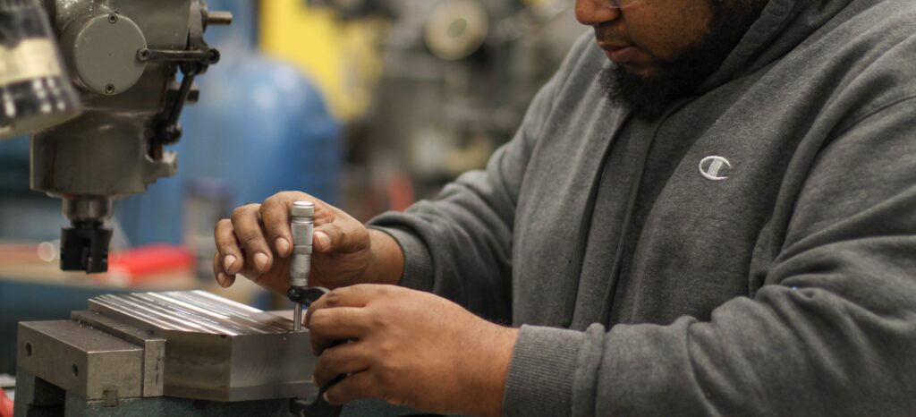 A man making adjustments to a machine.