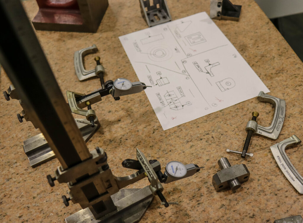 Blueprints on desk surrounded by tools.