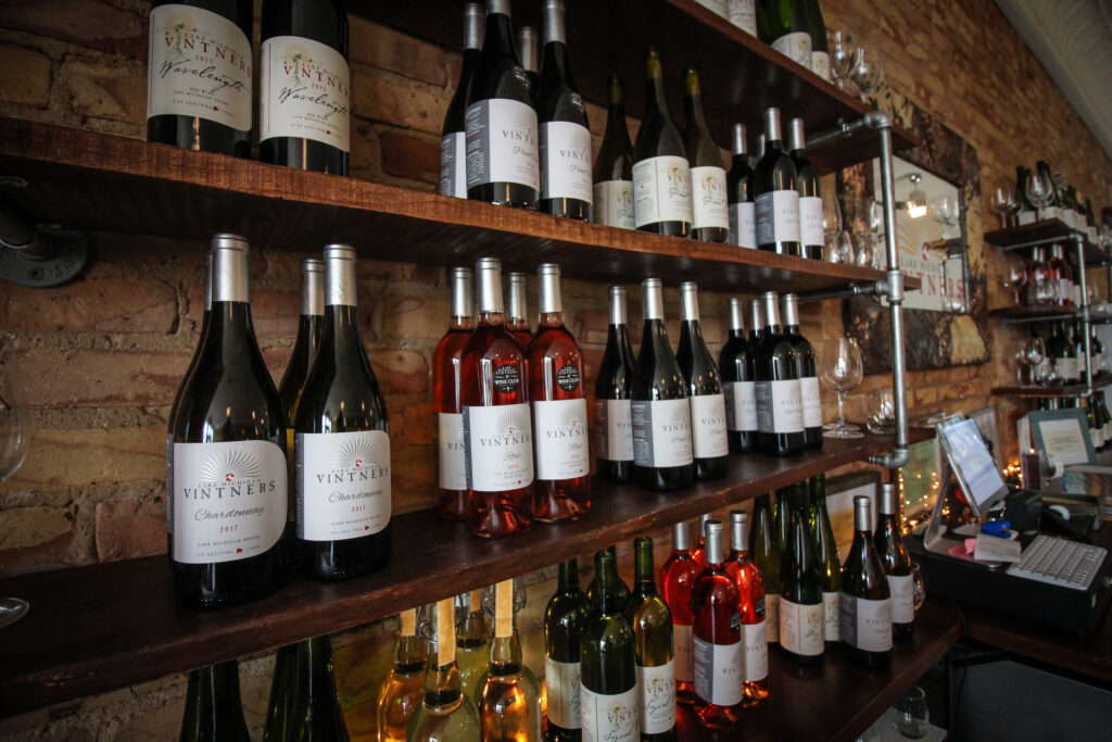 Wine bottles lined up neatly on shelf.