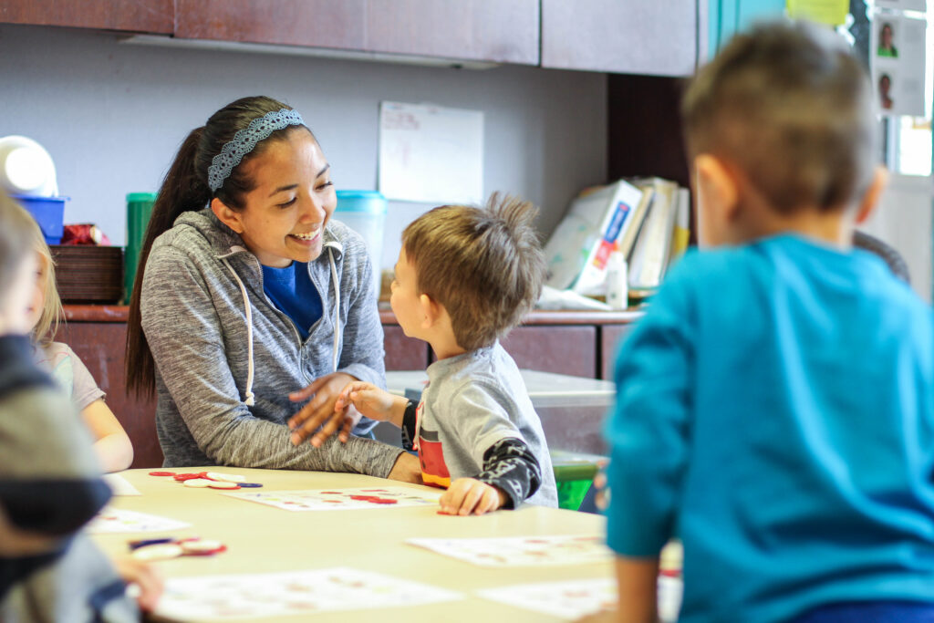 A woman smiling gently at a happy child.