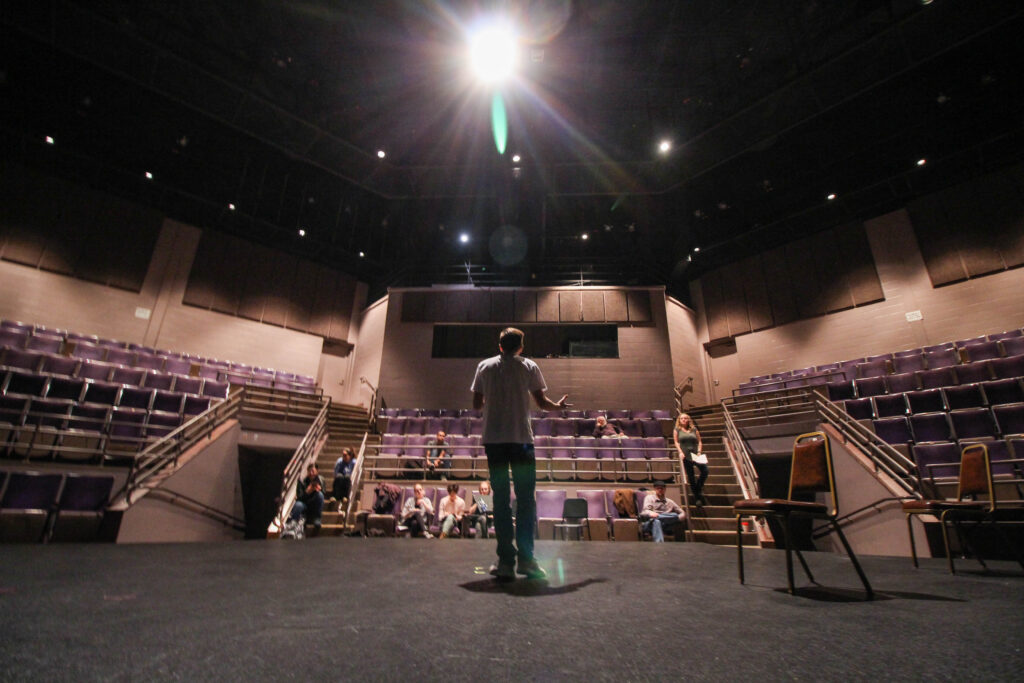 Man speaking on stage looking out to audience
