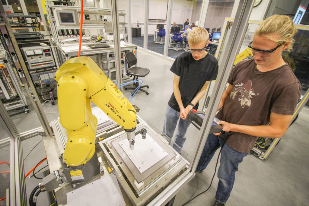 Two people observing a machine.