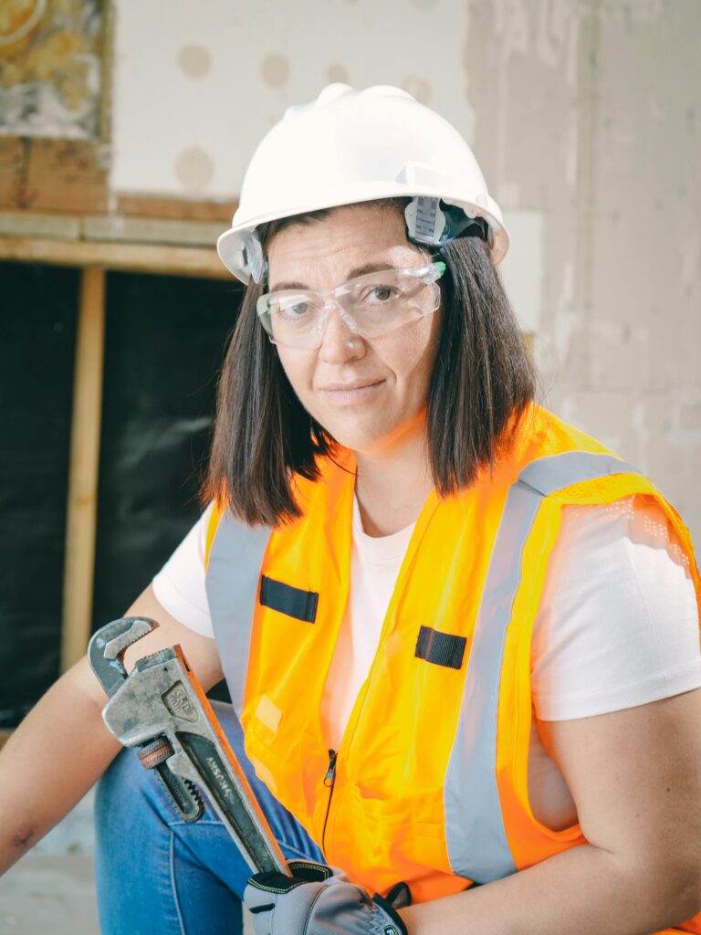 Woman in high-vis vest holding wrench