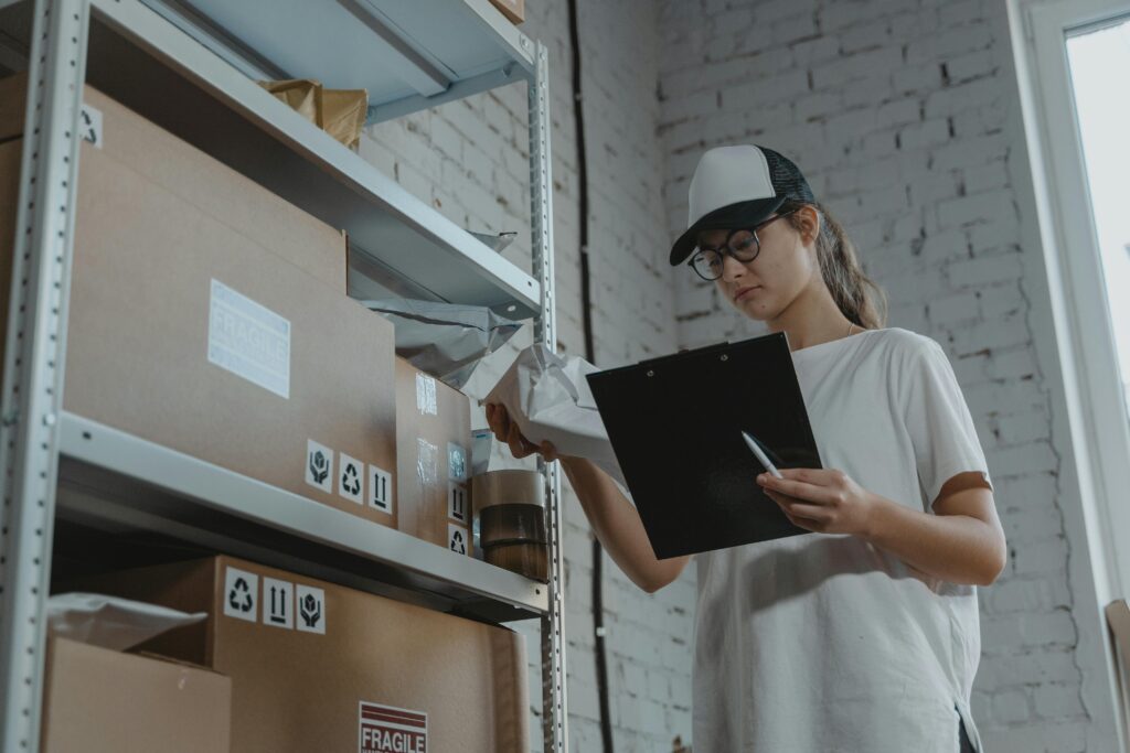 Woman holding clipboard next to storage shelves